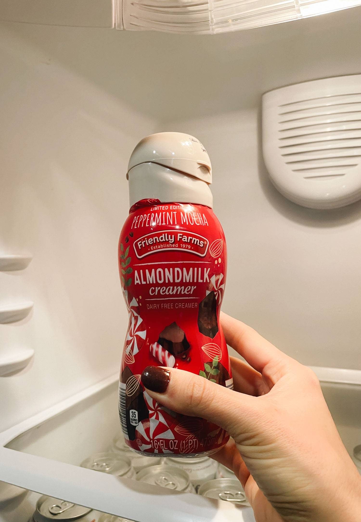 White hand holding peppermint creamer