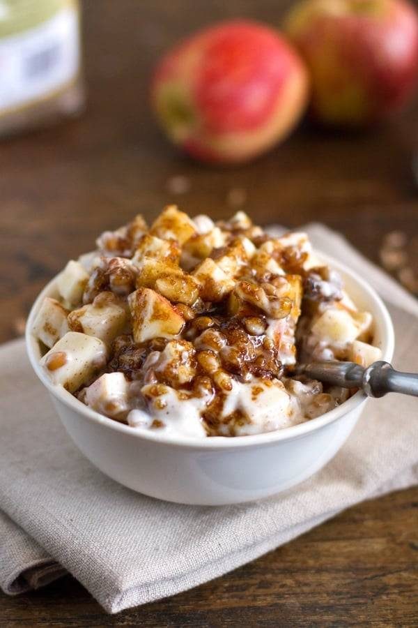 Yogurt parfaits with brown sugar, apples, wheat berries, flax, and walnuts in a bowl.