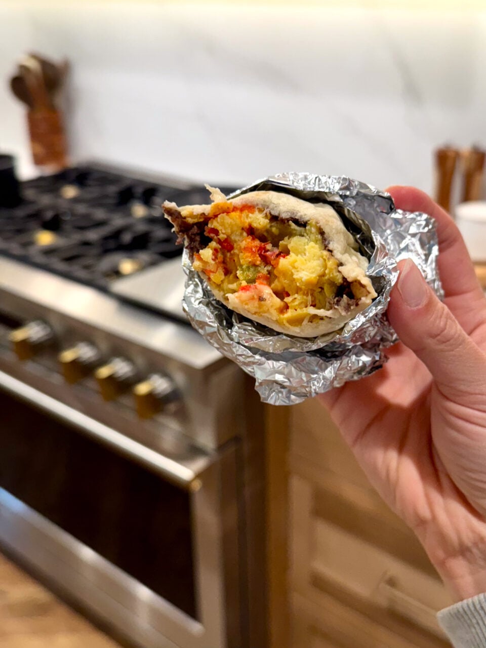 Breakfast burrito eaten in a foil wrap.