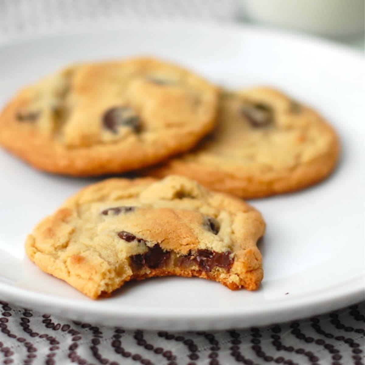 New York Times Chocolate Chip Cookies on a plate with a bite taken out.