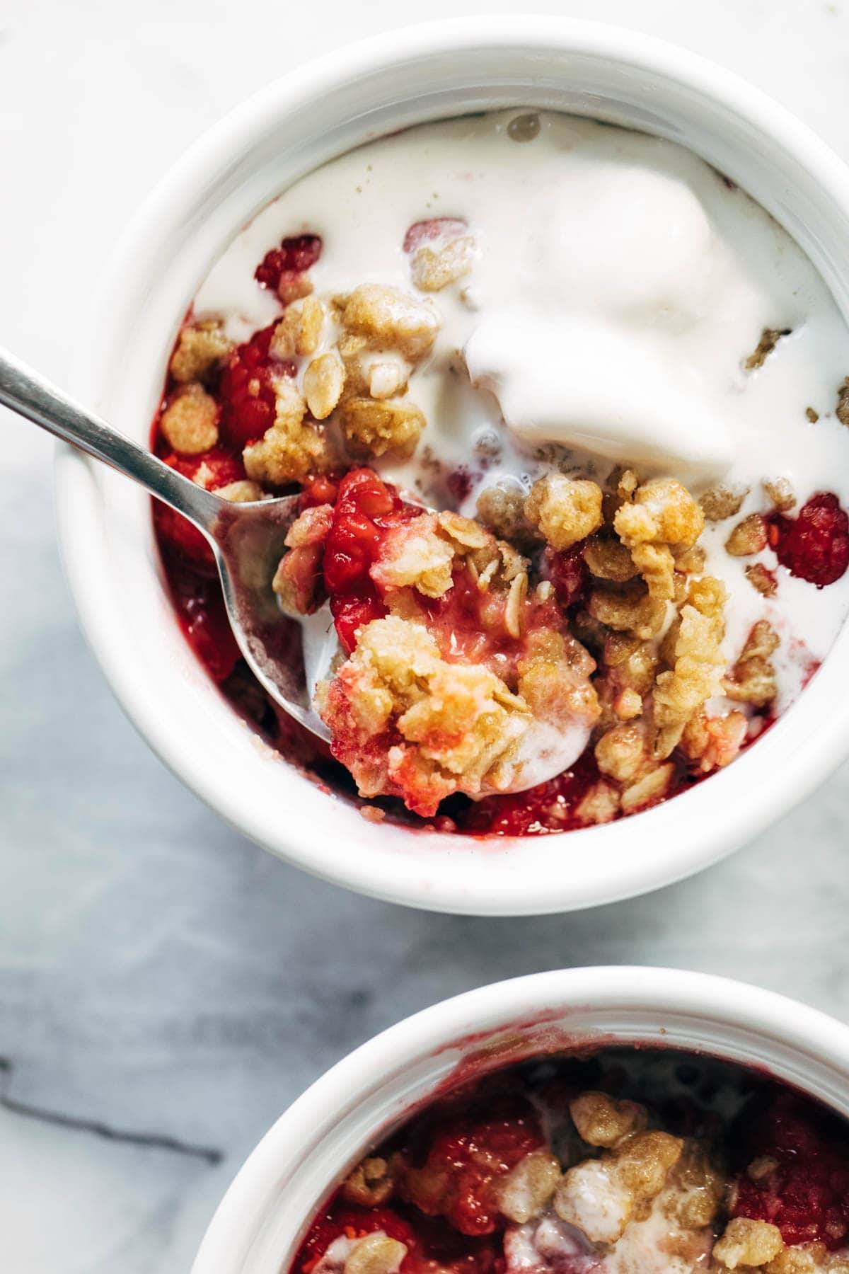 Raspberry crumble in a ramekin with ice cream.