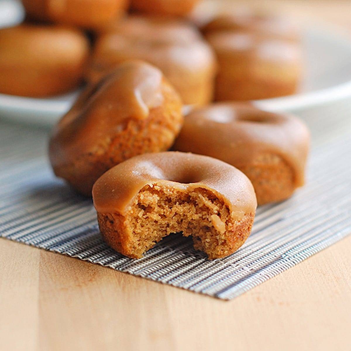 Baked Gingerbread Mini Donuts with a bite taken out of one.